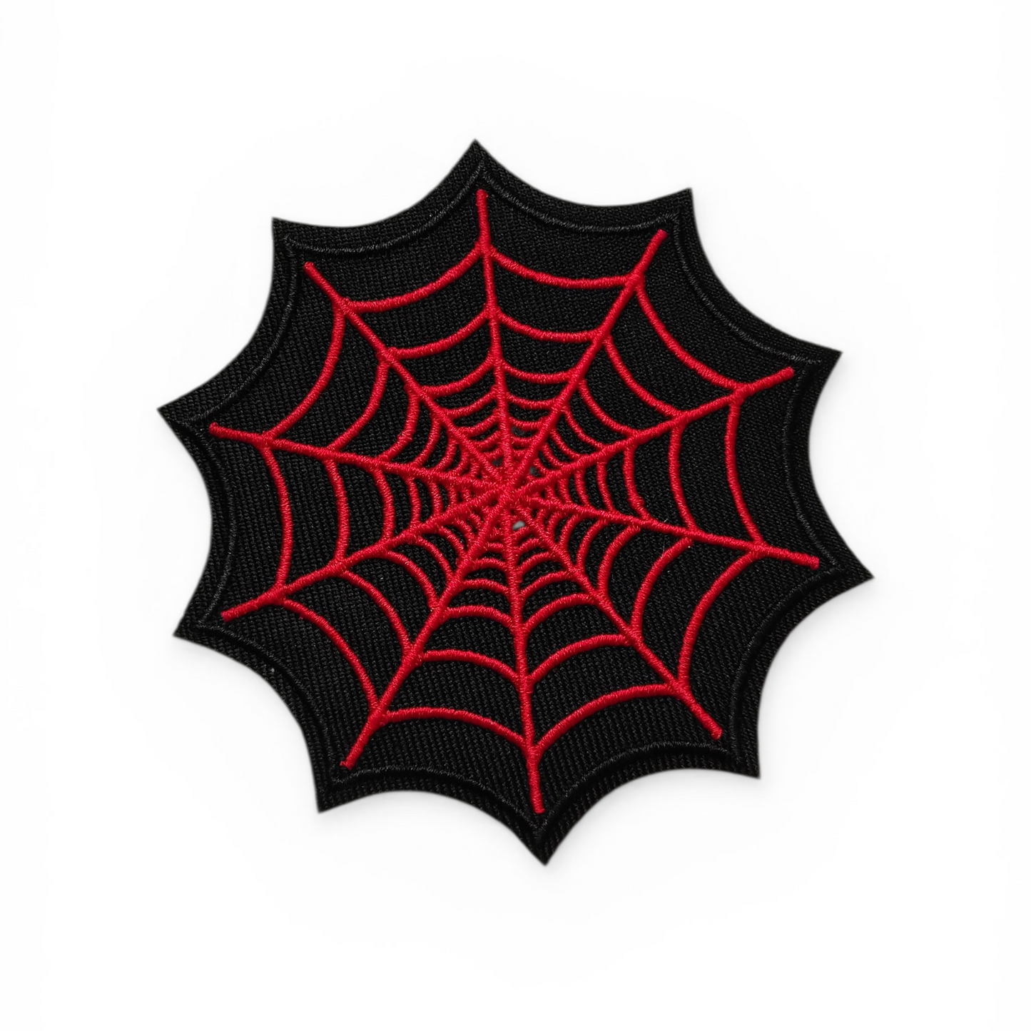 Black spider web patch with red detailing on a white background