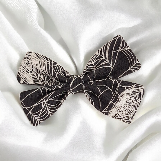 Black and white patterned bow on a white fabric background