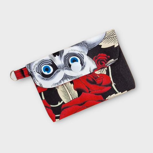 Fabric pouch with skull and rose design on a white background