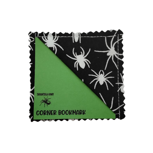 A square fabric corner bookmark with scalloped edges, featuring a black and white spider print on both sides.